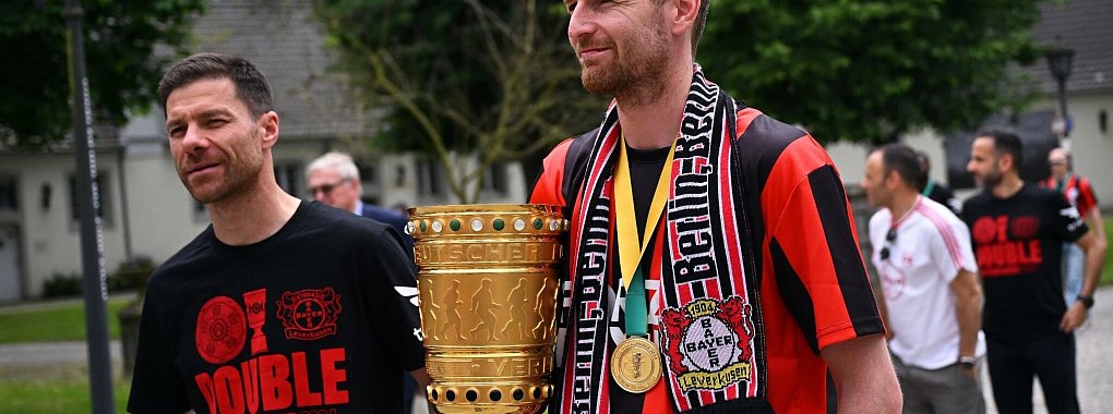 Leverkusens Trainer Xabi Alonso (l) und Leverkusens Torh&uuml;ter Lukas Hradecky kommen mit dem Pokal zum Schloss Morsbroich, um sich in das Goldene Buch der Stadt einzutragen. - &copy; Marius Becker/dpa