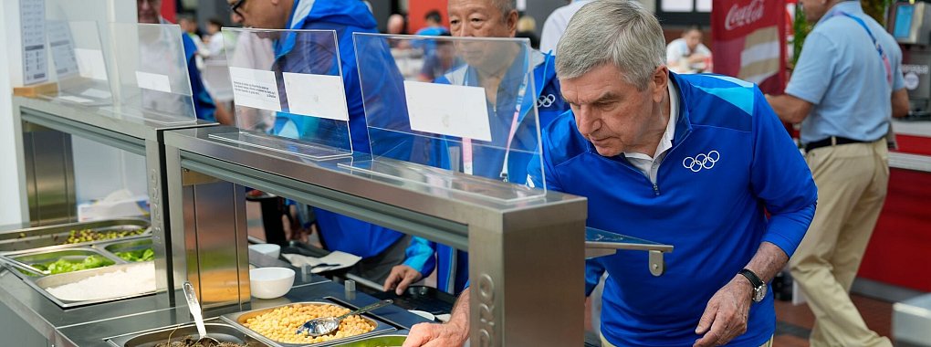 IOC-Pr&auml;sident Thomas Bach (r) testete auch das Essen im olympischen Dorf. - &copy; David Goldman/AP Pool/AP/dpa