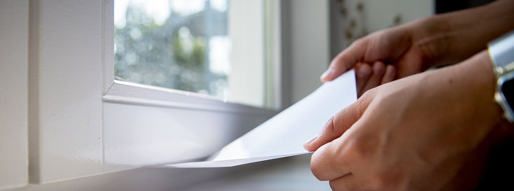 So findet man heraus, ob ein Fenster dicht ist: Ein eingeklemmtes Blatt Papier sollte fest sitzen. - © Zacharie Scheurer/dpa-tmn