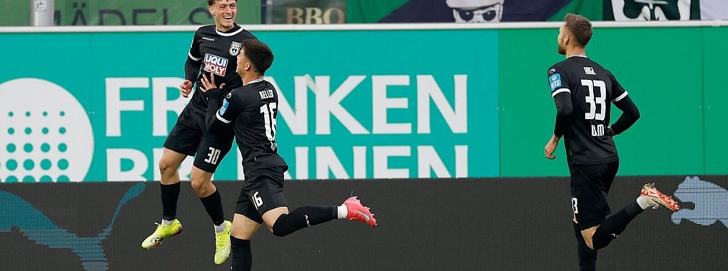 Die Ulmer Spieler feiern Matchwinner Maurice Krattenmacher (l) nach seinem Treffer. - © Heiko Becker/dpa