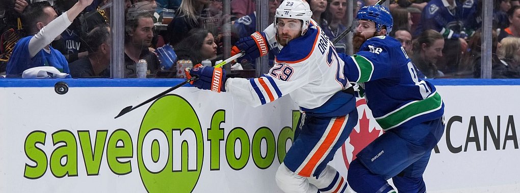 Edmontons Leon Draisaitl (l) im Zweikampf mit Ian Cole von den Vancouver Canucks. - &copy; DARRYL DYCK/The Canadian Press/AP/dpa