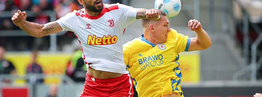 Der Regensburger Robin Ziegele (l) kämpft mit dem Braunschweiger Julian Baas um den Ball. - © Daniel Karmann/dpa