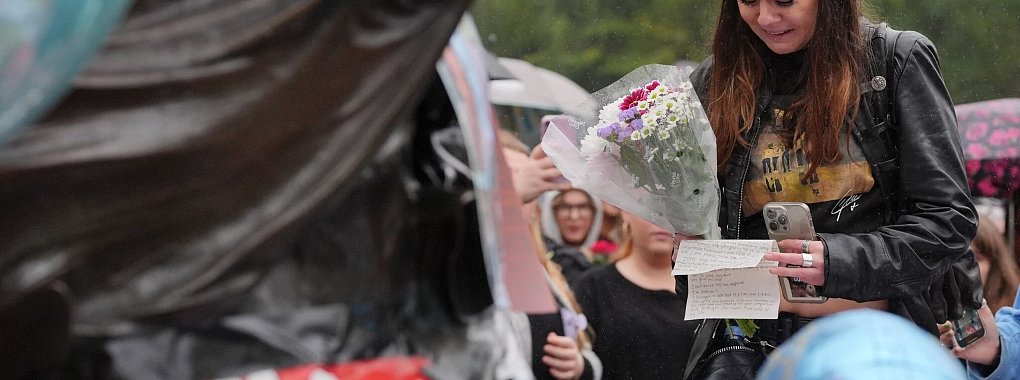 Fans legten Blumen und Briefe nieder und hielten Ballons. - © Jonathan Brady/PA Wire/dpa