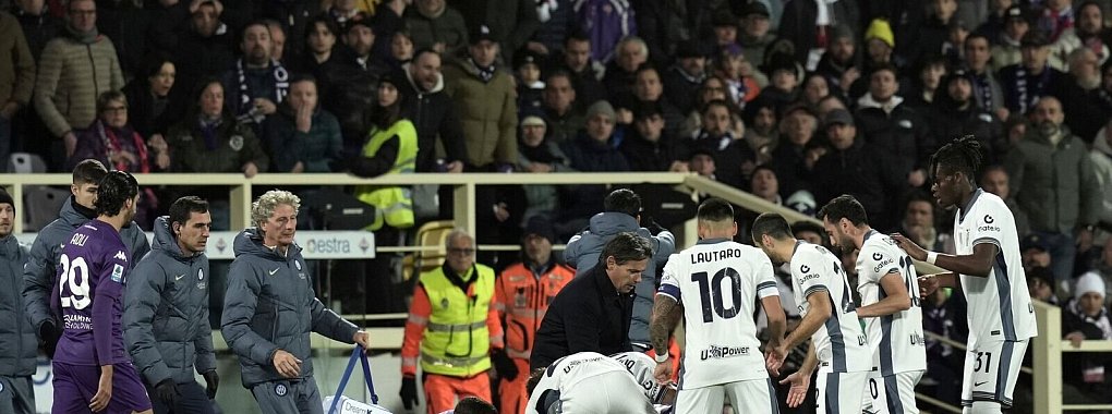 Spieler kümmern sich um den kollabierten Edoardo Bove. - © Massimo Paolone/LaPresse/AP/dpa