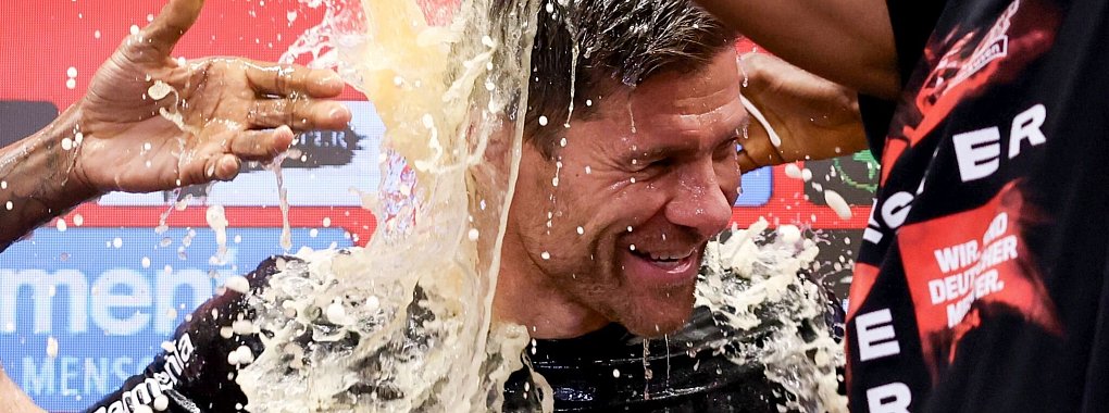 Fu&szlig;ball: Leverkusens Trainer Xabi Alonso wird bei der Pressekonferenz nach dem Spiel von seinen Spielern mit Bier &uuml;bergossen. Leverkusen gewinnt die Deutsche Meisterschaft. - &copy; Rolf Vennenbernd/dpa