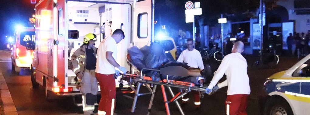 Rettungssanitäter bringen einen Verletzten zu einem Rettungswagen. - © Dominik Totaro/dpa