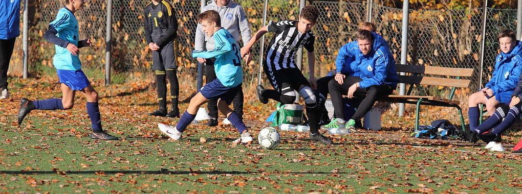 Einsatz im Herbstlaub auf dem Kunstrasenplatz: Werl-Aspes Alexander Löwen (rechts) setzt sich im C-Junioren-Spiel gegen Lemgos Andreas Fot durch. Im Hintergrund TBV-Trainer Lars Schrahe, auf der Bank: Christian Schulze (Fitnesstrainer). - © Kai Hahn
