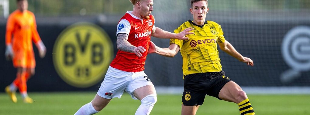 Alkmaars Mexx Meerdink (l) und Dortmunds Nico Schlotterbeck k&auml;mpfen um den Ball. - &copy; David Inderlied/dpa