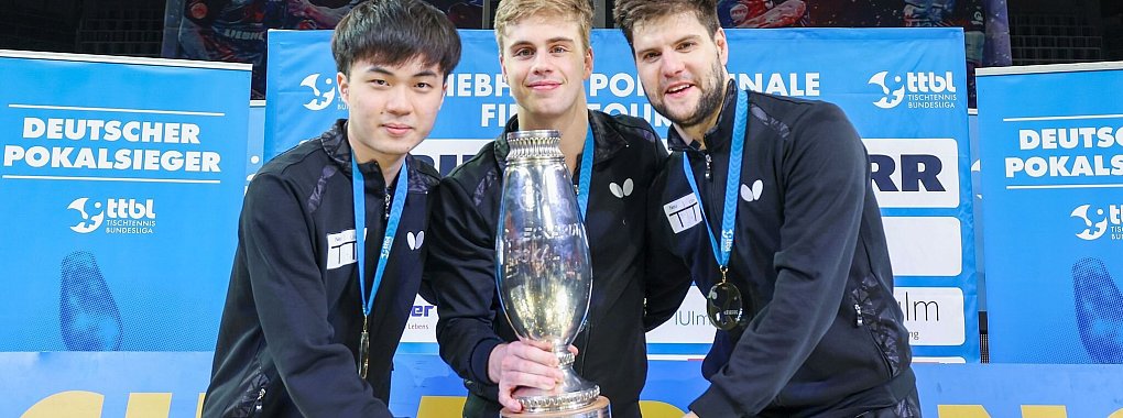 Lin Yun-ju (l-r), Truls Moregardh und Dimitrij Ovtcharov, alle von TTC Neu-Ulm, jubeln mit dem Champions-League-Pokal. In der Bundesliga spielt der Verein nicht mehr mit. - &copy; Joaquim Ferreira/dpa