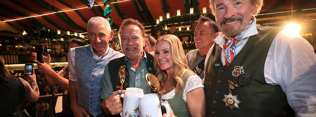 Die bekannte Riege der Wiesn-Promis - mit Schwarzenegger und Gottschalk. - © Karl-Josef Hildenbrand/dpa