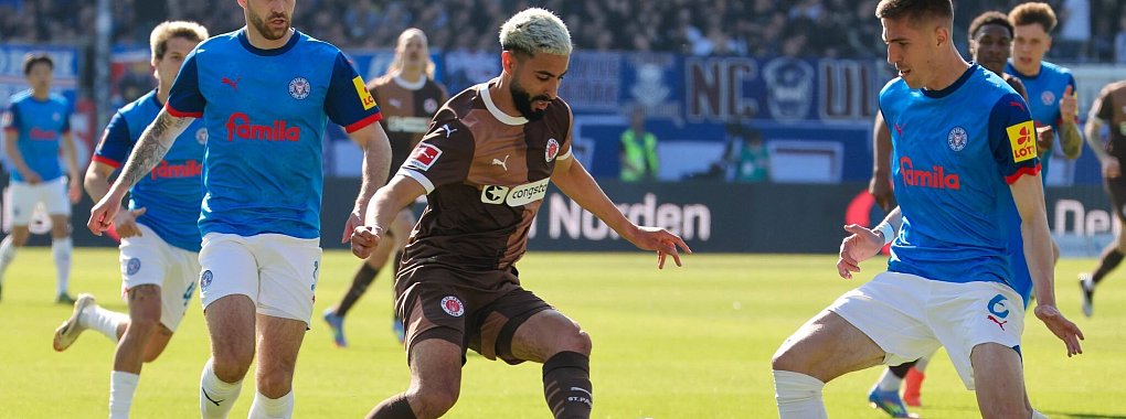 Kiels Marco Komenda (l-r), St. Paulis Elias Saad und Kiels Marko Ivezic kämpfen um den Ball. - © Frank Molter/dpa