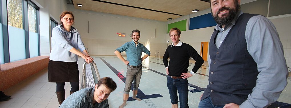 Rektorin Gudrun Laag checkt die Wassertemperatur im neuen Schwimmbecken der Astrid-Lindgren-Schule, auch Projektleiter Jörg Berkensträter (links) sowie Projektmanager Damian Grzonka (beide Firma Goldbeck) wagen sich ins Wasser vor, während Projektleiterin Andrea Berger (stehend) und Thomas von Heesen (beide Kreis Lippe) lieber mit dem Trockenen Vorlieb nehmen. - © Till Brand