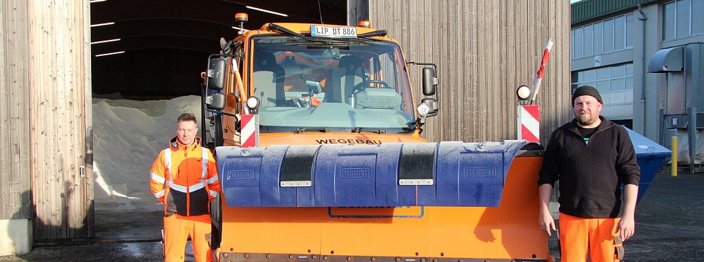 Andreas Hoffmann und Dennis Wehmeier vom Winterdienst der Stadt Detmold stehen mit dem Unimog vor der Salzhalle, die sich auf dem Bauhof befindet. - © Jana Beckmann