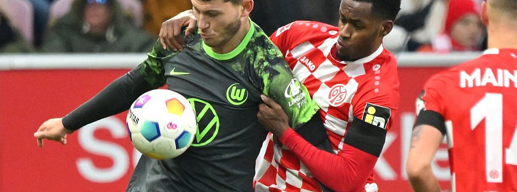 Wolfsburgs Jonas Wind (l) schirmt den Ball vor dem Mainzer Edmilson Fernandes ab. - &copy; Torsten Silz/dpa