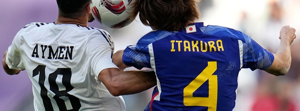 Iraks Aymen Hussein (l) und Japans Kou Itakura im Zweikampf um den Ball. - &copy; Aijaz Rahi/AP/dpa