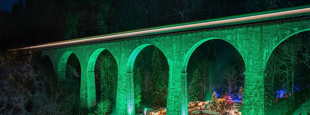 Illuminiertes Viadukt: Die Brücke der Höllentalbahn bietet eine einzigartige Kulisse für den Weihnachtsmarkt in der Ravennaschlucht. - © Hochschwarzwald Tourismus GmbH/dpa-tmn