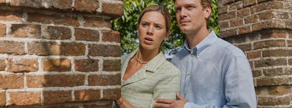 Máxima (Delfina Chaves) und Willem-Alexander (Martijn Lakemeier) verstecken sich hinter einem Mauervorsprung, Szene aus der Serie «Máxima», die schon bei RTL+ zu sehen war und nun im frei verfügbaren TV bei ZDFneo läuft. - © Martijn Van/Millstreet Films/ZDF/dpa