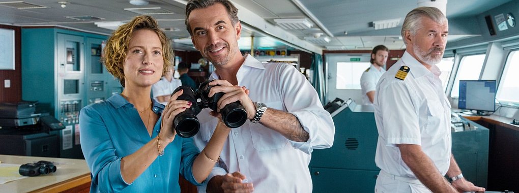 Kapitän Max Parger (Florian Silbereisen, M.) bringt zur Überraschung seines Staff-Kapitäns Martin Grimm (Daniel Morgenroth, r.) Veronika Bruckner (Wanda Perdelwitz) mit an Bord. - © Dirk Bartling/ZDF/dpa
