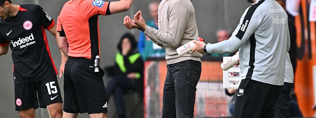 Aufreibender Tag am Spielfeldrand: Frankfurts Trainer Dino Toppmöller (r) bekommt von Schiedsrichter Florian Badstübner die Gelbe Karte gezeigt. - © Jan-Philipp Strobel/dpa