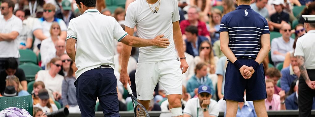 Alexander Zverev (r) geht zur&uuml;ck auf den Platz, nachdem ihm nach seinem Sturz ein Verband um sein Knie gewickelt worden ist. - &copy; Kirsty Wigglesworth/AP/dpa