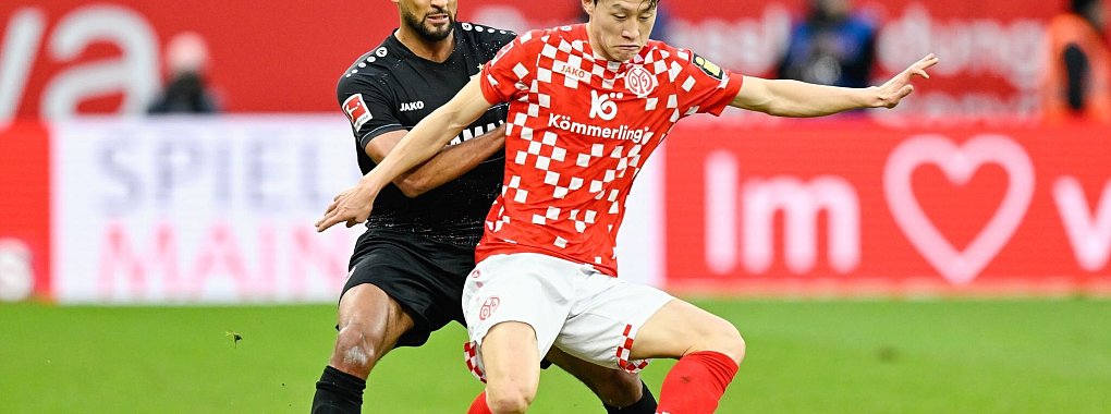 Stuttgarts Josha Vagnoman (l) und Jae-Sung Lee von Mainz 05 lieferten sich ein packendes Duell. - © Uwe Anspach/dpa