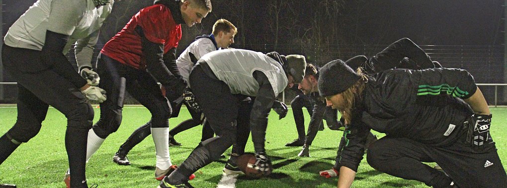 Anspannung liegt in der Luft, wenn sich Offensive Line (linke Bildh&auml;lfte) und die Defensive Line gegen&uuml;berstehen. Sobald der Center (Mitte) den Football an den Quarterback (Zweiter von links) &uuml;bergibt, geht es rund. - &copy; Vera Gerstendorf-Welle