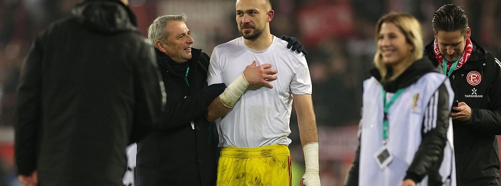 Klaus Allofs (2.v.l.) gratuliert Fortuna-Torwart Florian Kastenmeier zum Sieg. - &copy; Christian Charisius/dpa
