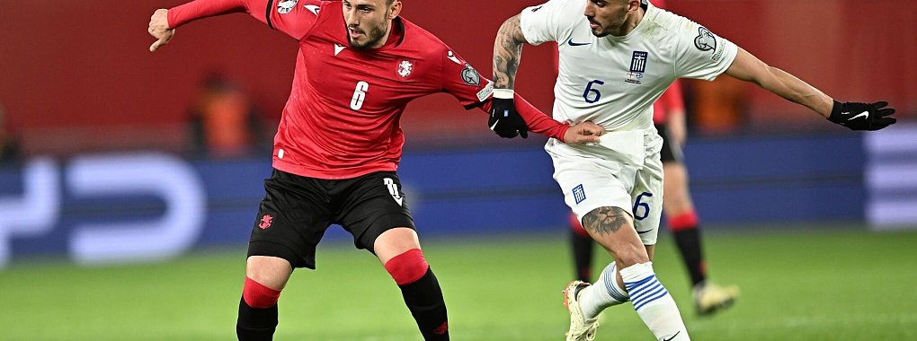 Der Georgier Giorgi Kotschoraschwili (l) behauptet den Ball gegen Dimitris Kourbelis. - &copy; Tamuna Kulumbegashvili/AP/dpa