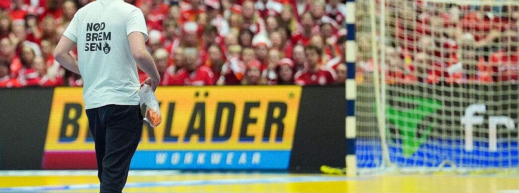 Ein mutmaßlicher Klimaaktivist verstreut Papierschnipsel beim WM-Spiel zwischen Dänemark und Tschechien. - © Soeren Stache/dpa