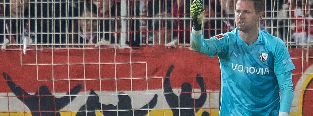Bochums Keeper Patrick Drewes hält das Feuerzeug hoch, das ihn getroffen hat. - © Andreas Gora/dpa