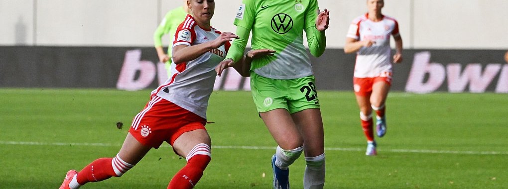 Bayern Münchens Giulia Gwinn (l) im Zweikampf mit Jule Brand vom VfL Wolfsburg. - © Angelika Warmuth/dpa