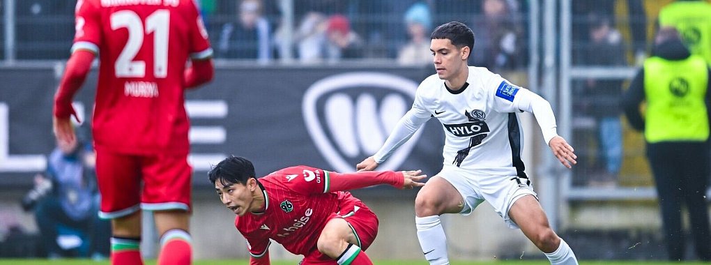 Hannover am Boden: Hyun-Ju Lee im Duell mit Elversbergs Frederik Schmahl. - © Silas Schueller/DeFodi Images/dpa