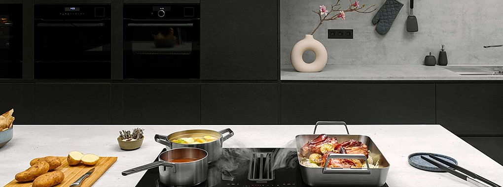 Ganz nach unten geht es f&uuml;r den Kochdunst mit einem in das Kochfeld integrierten Abzug. - &copy; AMK/dpa-tmn