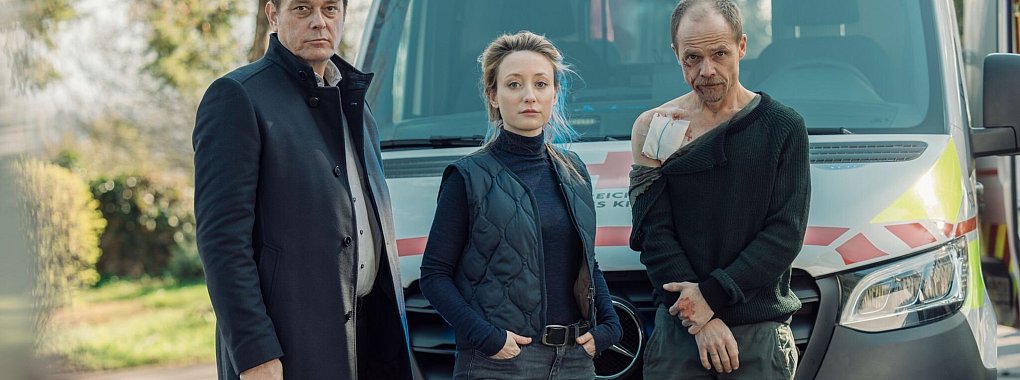 Der verletzte Micha Oberl&auml;nder (Matthias Koeberlin, l-r), Luisa Hoffmann (Alina Fritsch) und Thomas Komlatschek (Hary Prinz) stehen zusammen vor einem Notarztwagen. - &copy; manuelpaul/ZDF/dpa