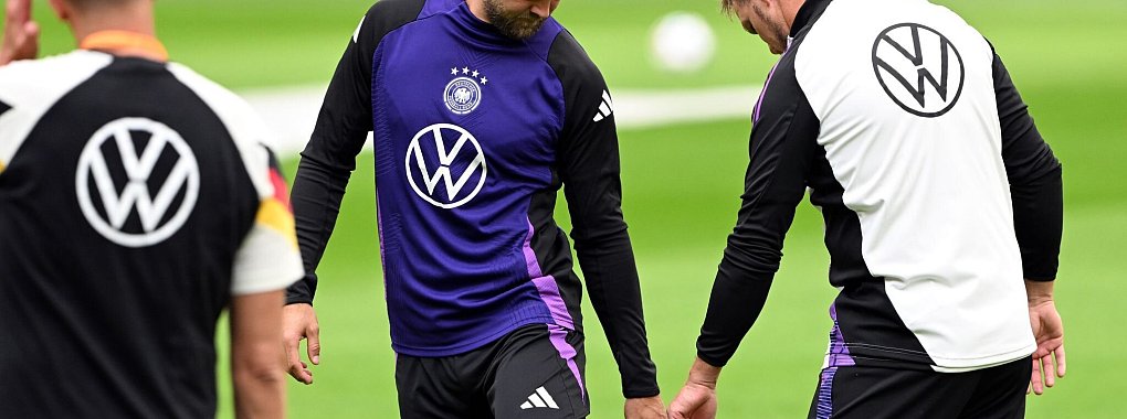 Niclas Füllkrug (M) nach seinem vergeblichen Härtetest beim Abschlusstraining im Gespräch mit Bundestrainer Julian Nagelsmann (r). - © Federico Gambarini/dpa
