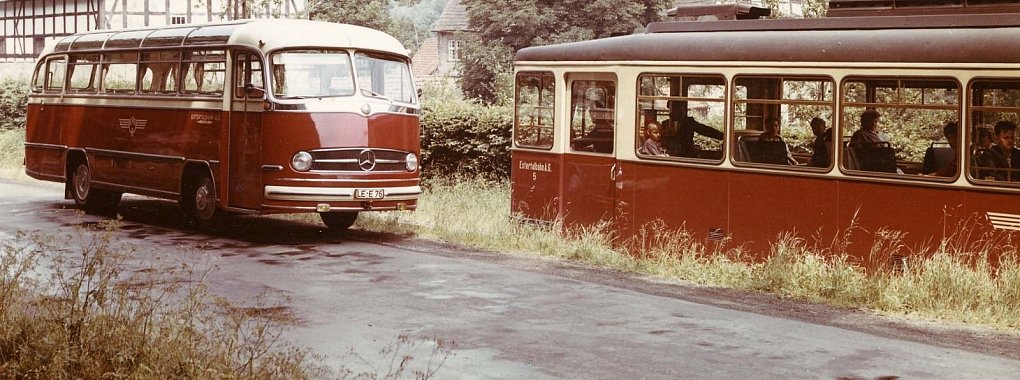 Personenverkehr auf der Extertalbahn: 1969 wurde die Bahn ganz durch den Bus ersetzt. Hier ein historisches Foto, das beide Verkehrsmittel vor Gut Ullenhausen zeigt.  - © Verkehrsbetriebe Extertal