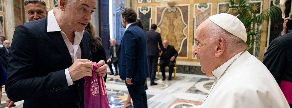 Der Komiker Michael Mittermeier &uuml;berreicht Papst Franziskus bei einer Audienz ein DFB-Trikot. - &copy; Vatican Media/dpa