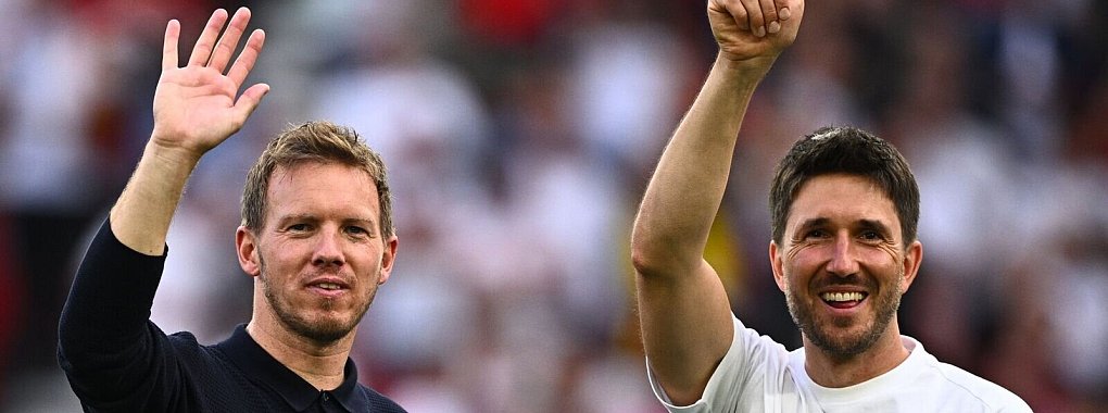 Bundestrainer Julian Nagelsmann (l.) und sein Co-Trainer Benjamin Gl&uuml;ck winken ihren Familien zu. - &copy; Tom Weller/dpa