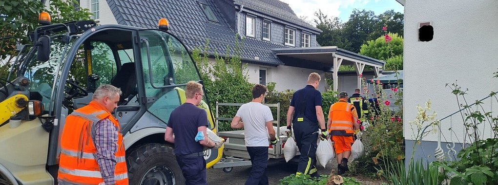 21 Kräfte der Schieder-Schwalenberger Feuerwehr helfen, Sandsäcke zum Abpuffern der kontrollierten Sprengung in den Garten zu tragen. - © Marianne Schwarzer