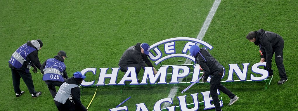 Helfer bauen das Logo der Champions League auf. - © Rolf Vennenbernd/dpa