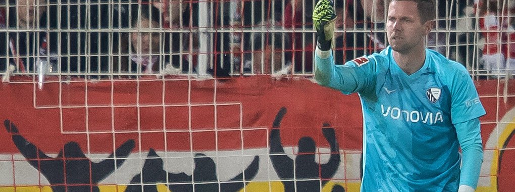 Bochums Keeper Patrick Drewes hält das Feuerzeug hoch, das ihn getroffen hat. - © Andreas Gora/dpa