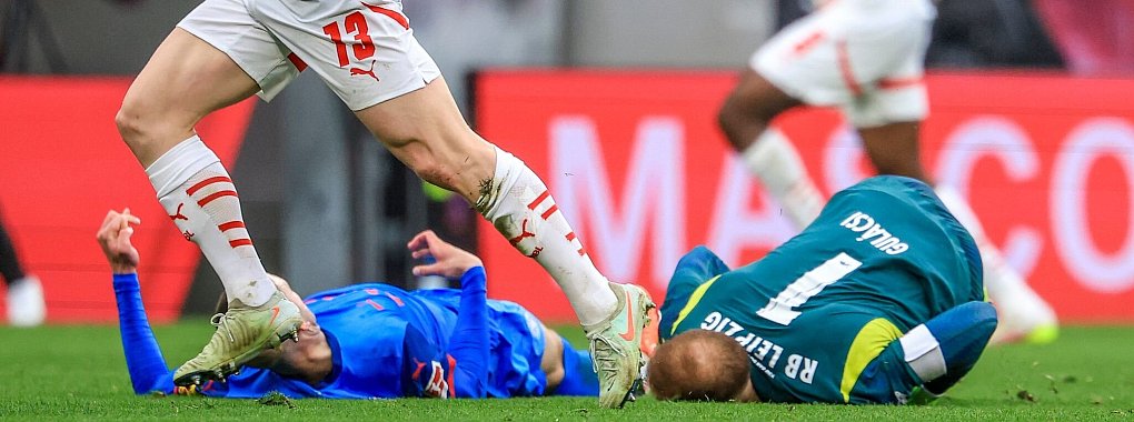 Peter Gulacsi (r) und David Zec gehen nach dem Zusammenprall zu Boden. - © Jan Woitas/dpa