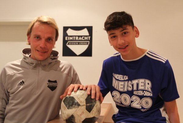 In der Vereinskneipe des SVE Jerxen-Orbke stellen sich Trainer Florian Bobe und C-Junioren-Spieler Samih Uslu fürs Foto auf. - © Sebastian Lucas