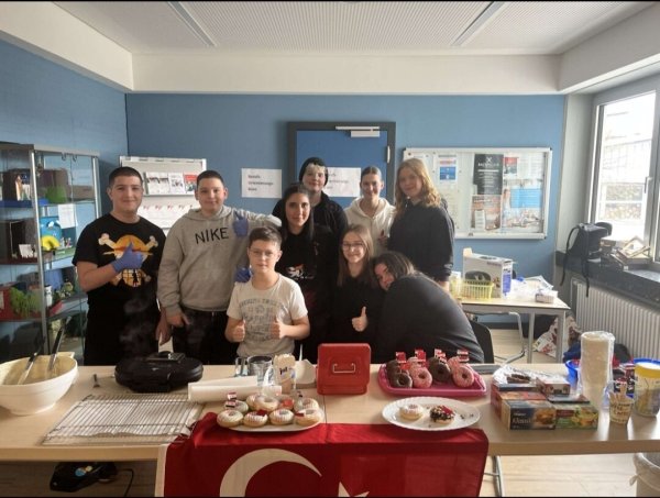 Kadir (von links), Seyyit (beide achte Klasse), Joel (fünfte Klasse), Zeinab, Lea, Nelly, Leonie, Jasmin und Leoni (alle zehnte Klasse) freuen sich, dass ihr Verkauf von Waffeln und weiteren Leckereien so erfolgreich gewesen ist. - © Sekundarschule Blomberg