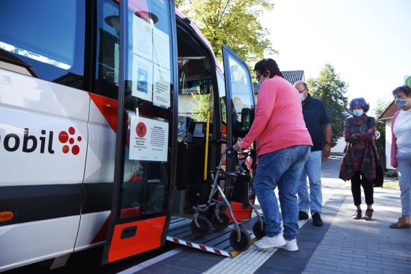 Gisela Kaiser testet mit ihrem Rollator den Einstieg an der neuen barrierefreien Haltestelle in Langenholzhausen. Axel Bünger vom Bürgerbusverein, sowie Renate Lübbing (Mitte) und Heidelore Müller vom Seniorenbeirat schauen gespannt zu. - © Raphael Bartling