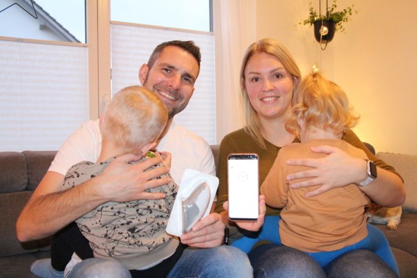 Dennis Zobel mit Sohn Emil, der mit knapp 13 Monaten an Diabetes Typ I erkrankt, und dem Sensor zur Messung des Gewebezuckers. Daneben Verena Zobel mit Tochter Leni und dem Handy, über das die aktuellen Zuckerwerte abgelesen werden können. - © Freya Köhring(LZ)