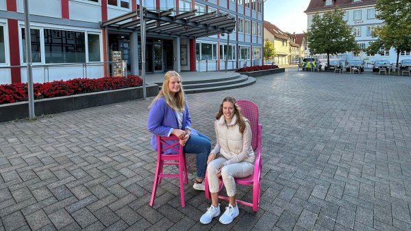 Lea Steinhage (links) und Kira Milutinovic, Gleichstellungsteam der Stadt Lügde, machen mit den pinken Stühlen auf das Thema Brustkrebs aufmerksam. - © Stadt Lügde