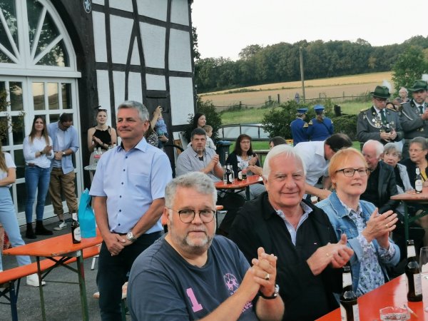 Kommunalpolitiker Jobst-Dieter Rodewald-Tölle (Mitte stehend) nimmt inmitten von geladenen Gästen aus Politik und Verwaltung gerührt die feierliche Verabschiedung aus dem politischen Leben im Rahmen eines Großen Zapfenstreiches auf seinem Hof in Selbeck entgegen. - © Sylvia Frevert