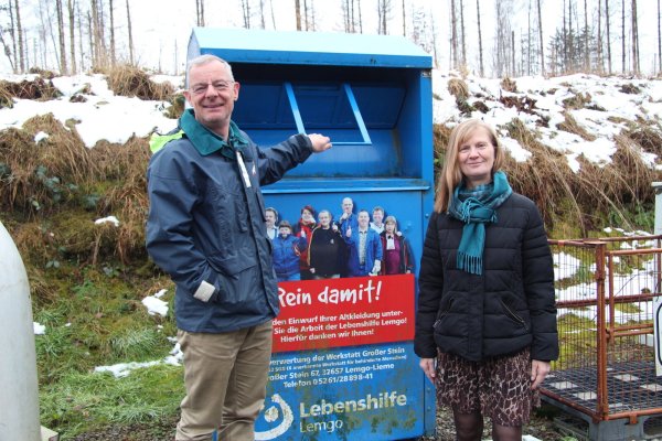 Axel Mayer von der Abfallbeseitigungsgesellschaft und Regine Lükermann vom Abfallwirtschaftsverband zeigen einen Altkleider-Container auf dem Recyclinghof an der Maibolte. - © Nadine Uphoff