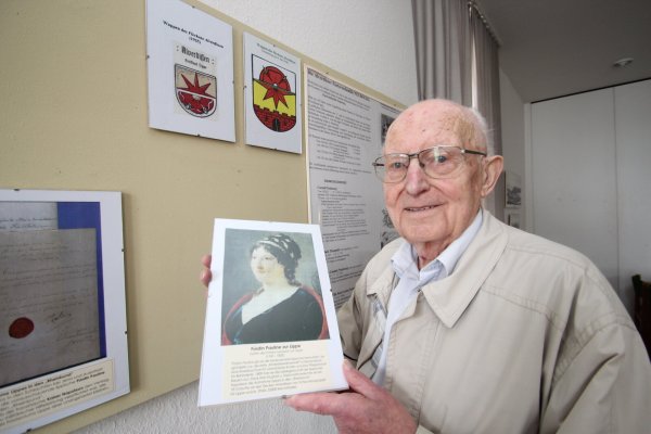 Helmuth Welsch zeigt ein Bild von Fürstin Pauline. Im Hintergrund ist das Alverdisser Wappen zu sehen. - © Jens Rademacher